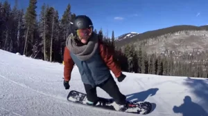 Amy Purdy riding a snowboard on a groomed run at Copper Mountain, still released by LightbeamTV