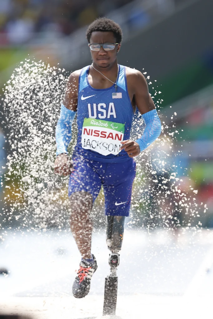 Desmond Jackson of the United States competing in the men’s T42 long jump at the Rio 2016 Paralympic Games, wearing a below-the-knee sports prosthesis. Photograph by Fernando Frazao, Agencia Brasil, Creative Commons Attribution 2.0 licence.